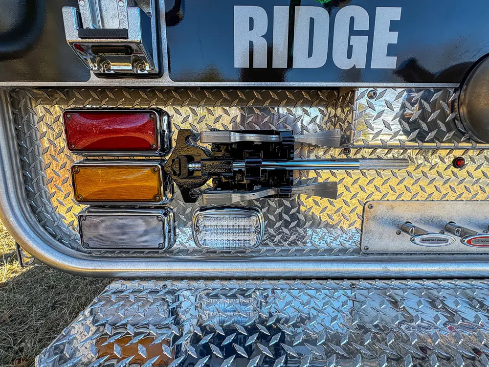 Rear corner close-up with taillight, body hardware, and step edge.