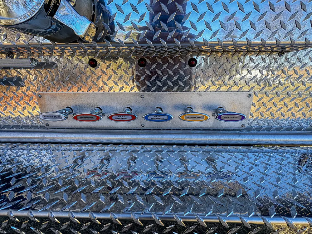 Diamond-plate top-deck close-up with a row of circular mounting points.