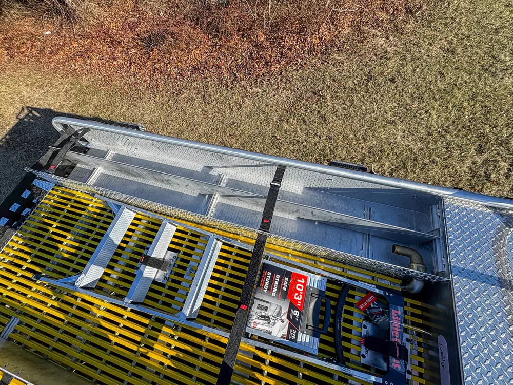 Top-deck view across side rails and grated panels with stored gear.