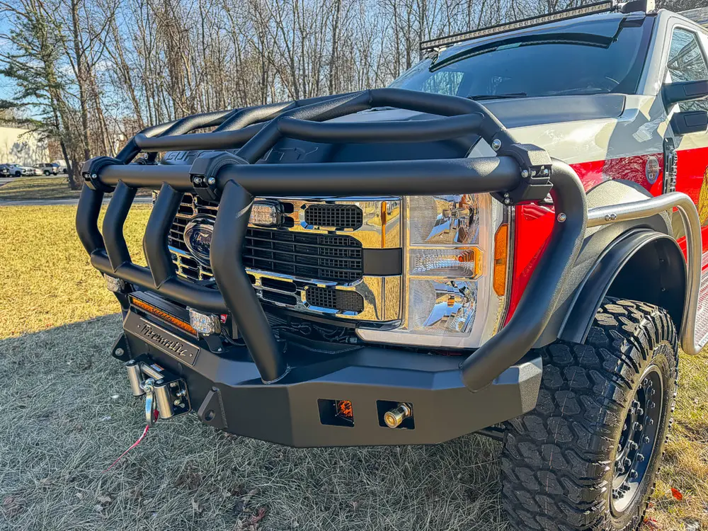 Front-left corner close-up of grille, brush guard, and bumper.