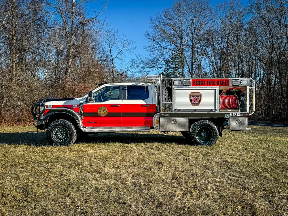 Wide left-side profile with cab and utility body compartments visible.