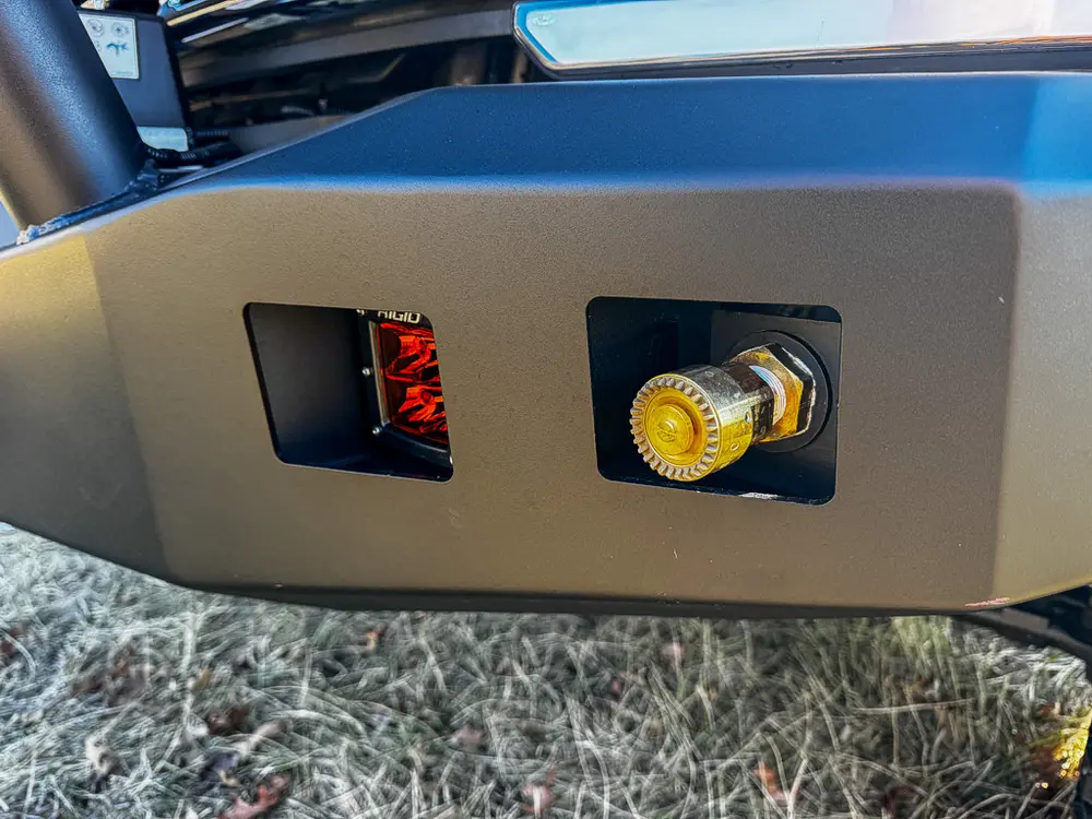 Front bumper close-up with mounted outlet connection and recessed light.