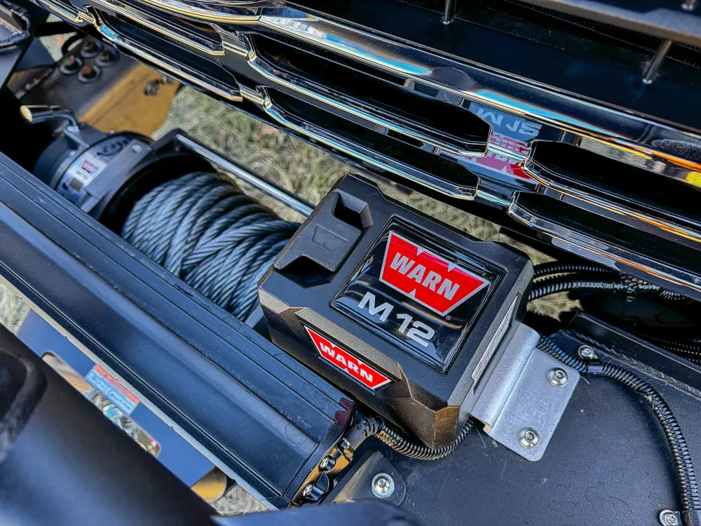 Close-up of the front bumper winch with cable and control housing.