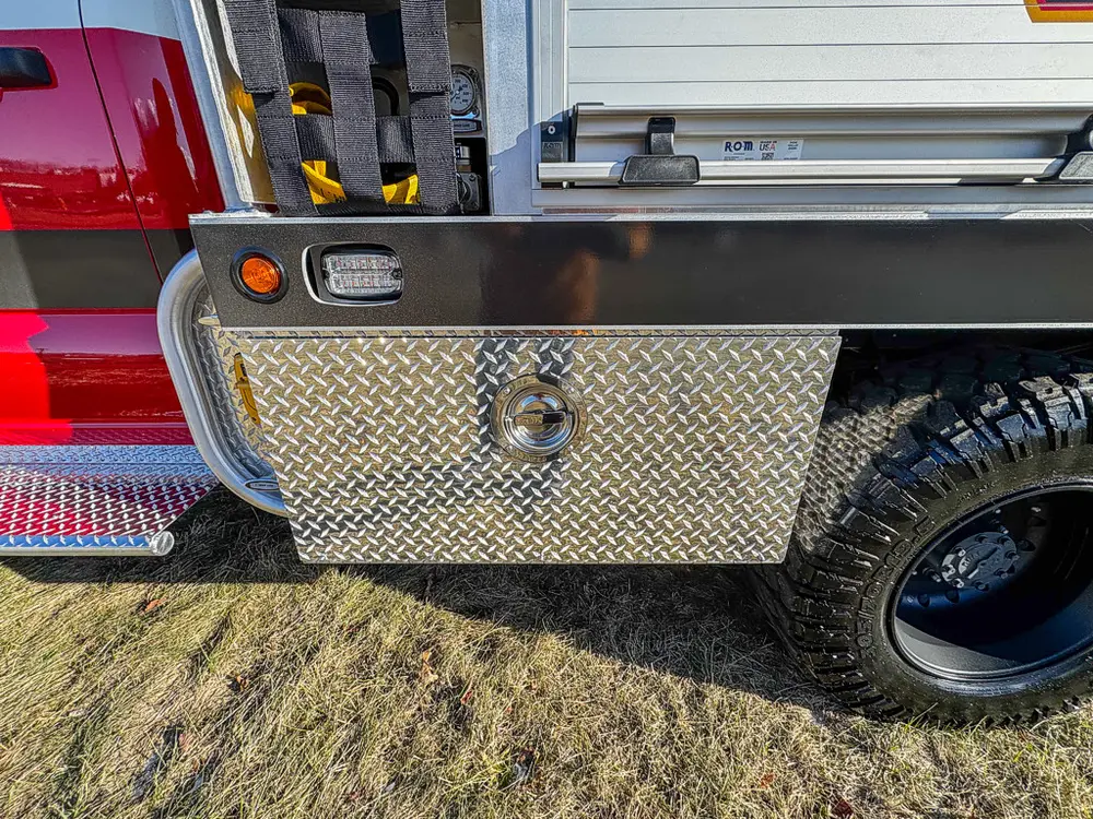 Lower side body and rear wheel area with closed diamond-plate compartment.