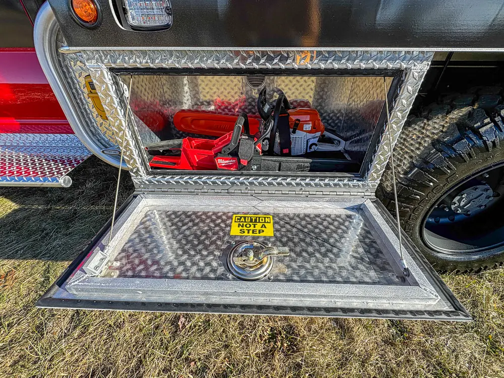 Open lower side compartment with mounted rescue tools on a tray.