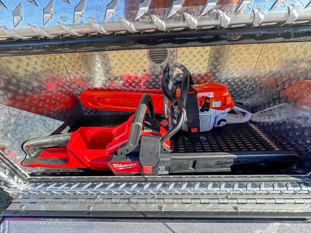 Compartment close-up showing red rescue tool and battery pack.