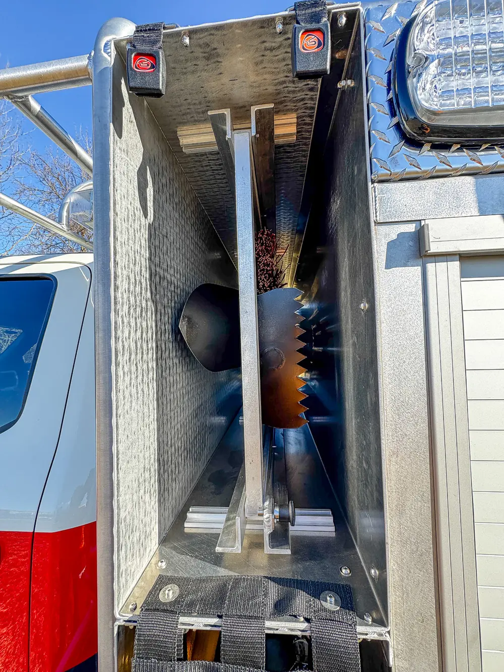 Compartment interior close-up with metal cutting blade and dark storage bin.