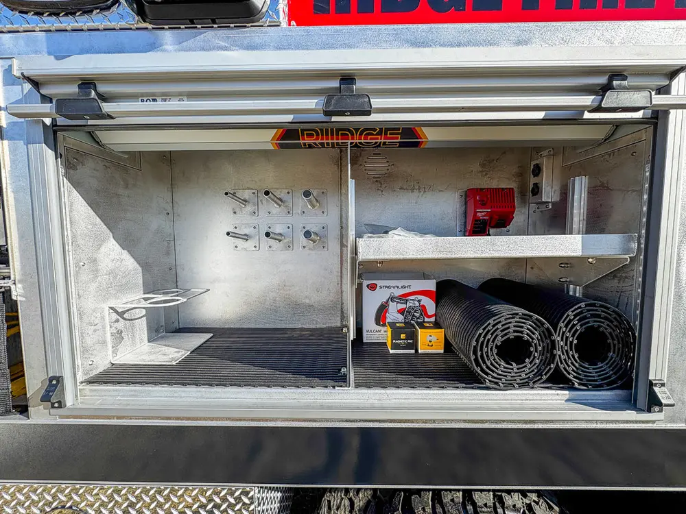 Open upper side storage compartment with shelves and loose equipment.