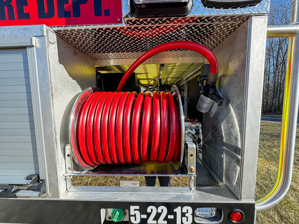 Open compartment with red hose reel mounted under the upper shelf.