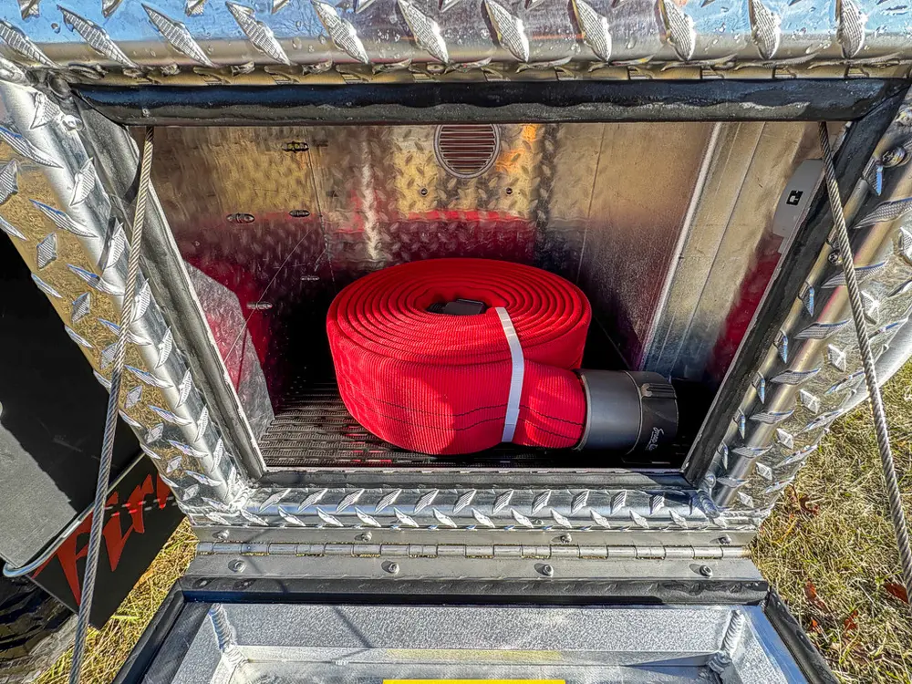 Compartment interior close-up with red rolled strap secured in storage.