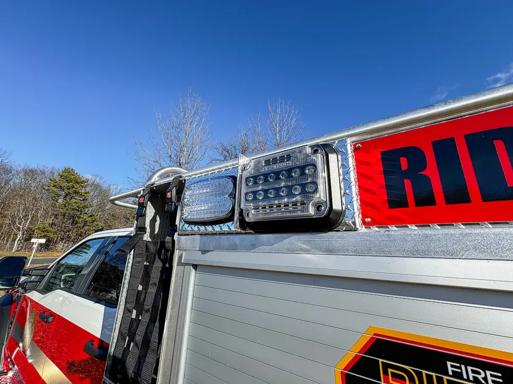 Upper side body close-up with warning lights and reflective red stripe.