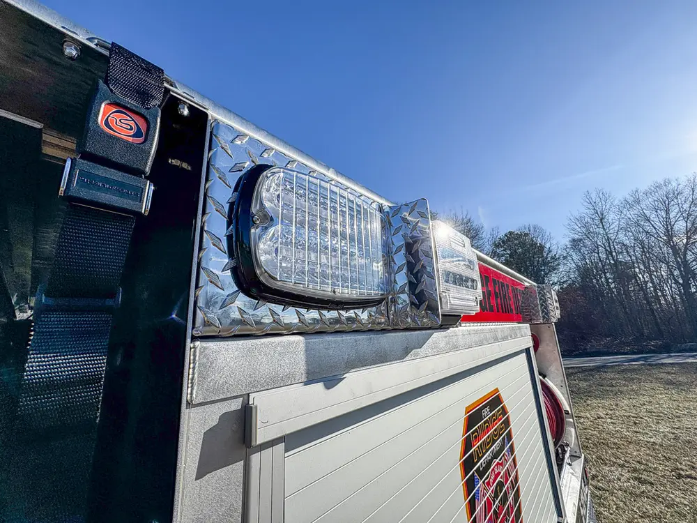 Rearward upper-body angle showing scene light housing and side rail.