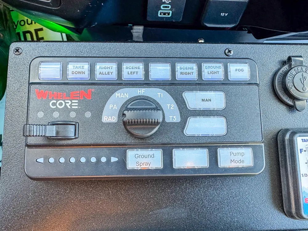 Close-up of Whelen control panel and adjacent in-cab switch hardware.