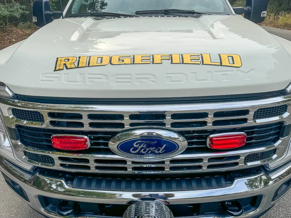 Head-on grille close-up with Ford emblem and red warning lights.