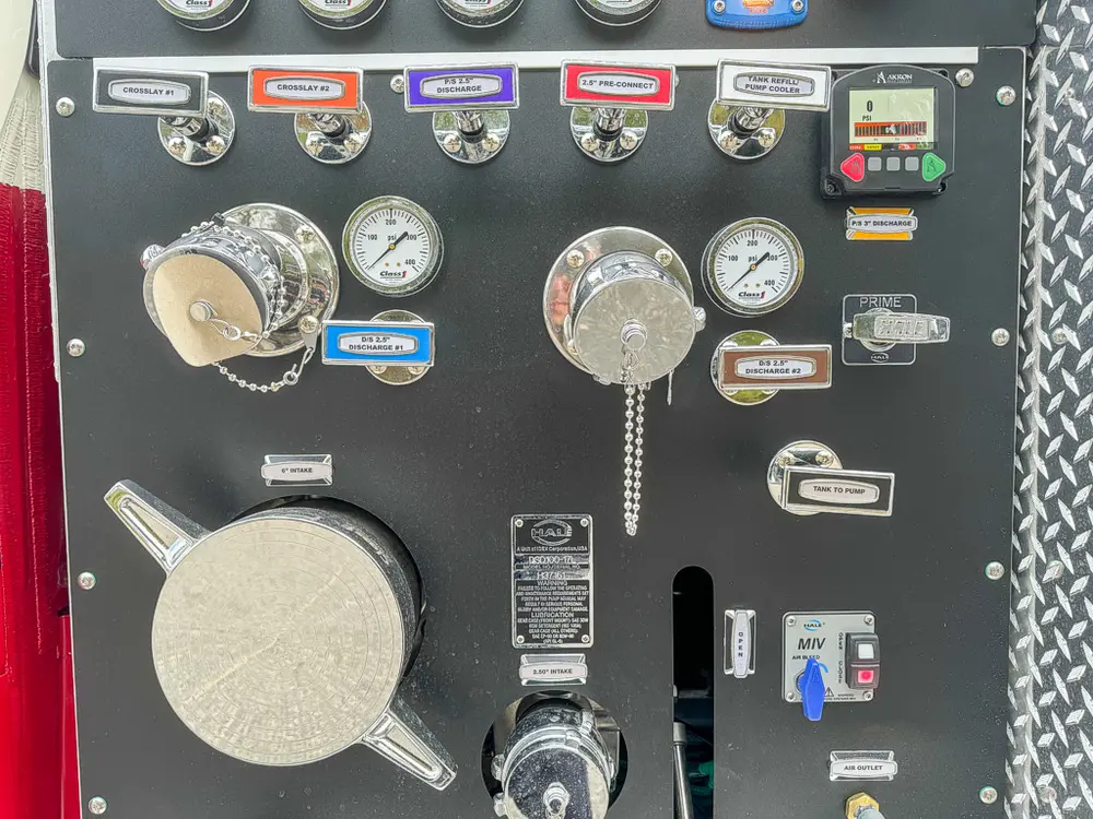 Pump panel close-up showing capped inlets, gauges, and labels.