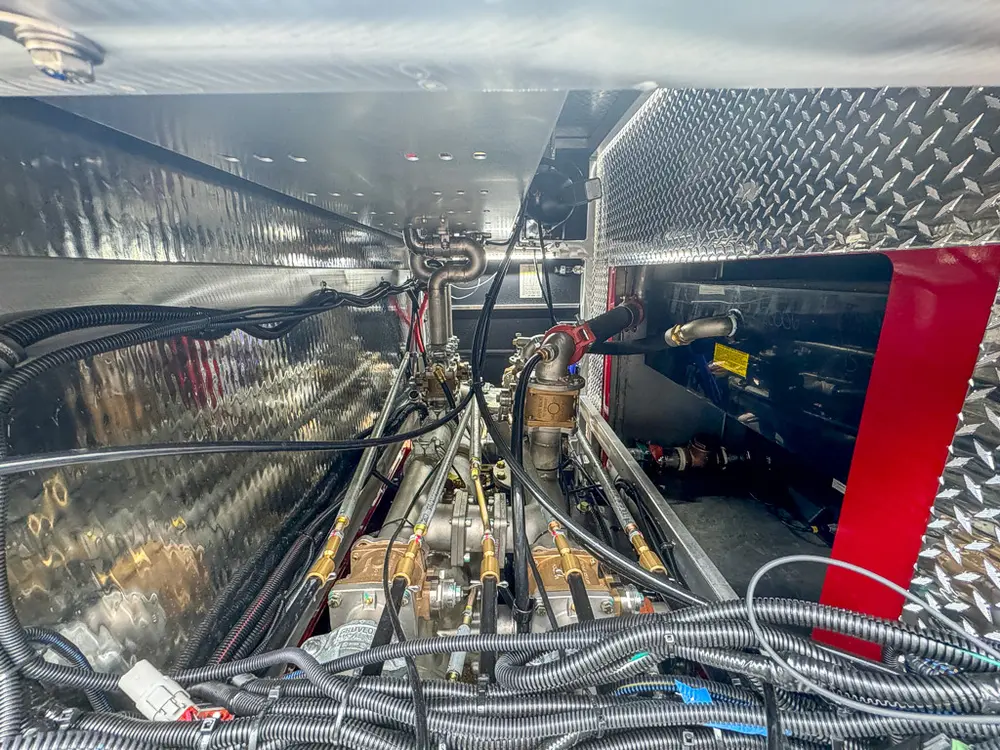 Deep side equipment bay with hoses and tools inside.