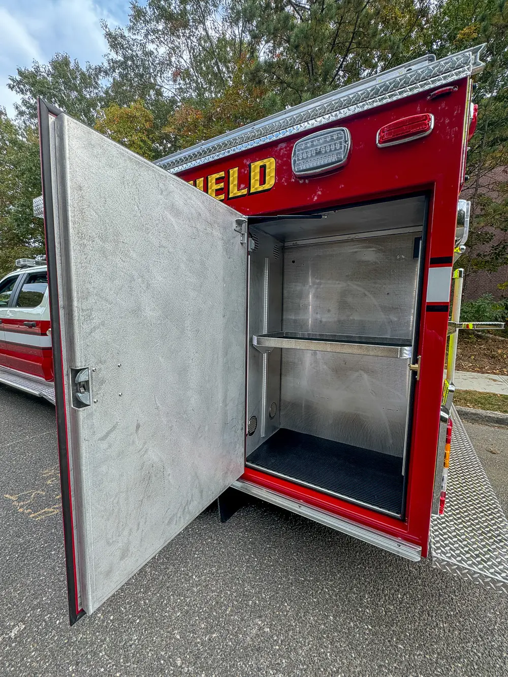 Open side compartment with shelf and smooth metal interior.