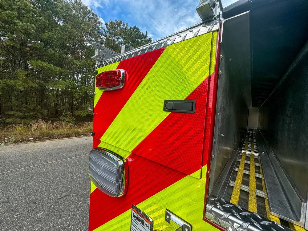 Rear-left corner close-up with chevron and open deck edge.