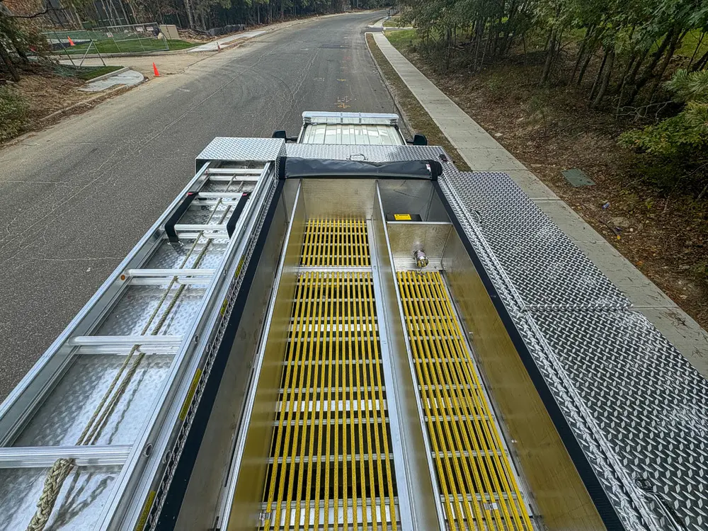 Top deck view along yellow grate with ladder and side rails.