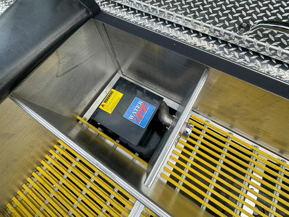 Open top hatch on deck showing battery compartment beneath grating.