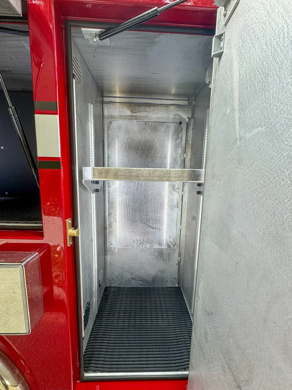 Vertical side compartment with shelf and empty metal interior.