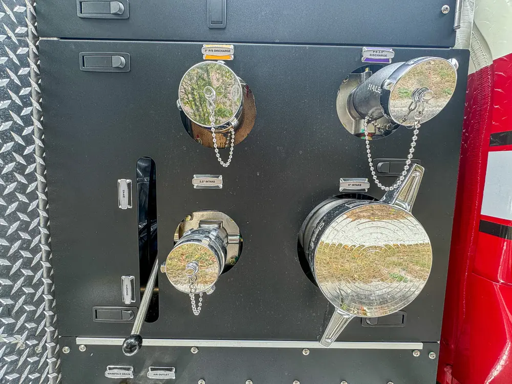 Pump panel close-up with large capped inlets and control handles.