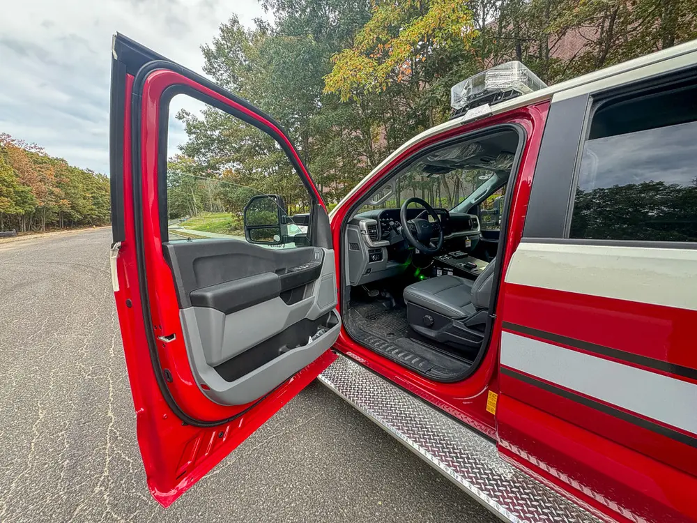Open driver door view into front cabin with steering wheel visible.