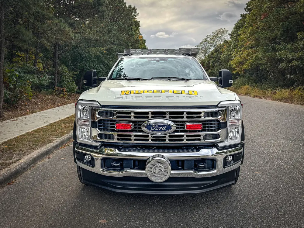Head-on front view with grille lights and bumper-mounted siren.