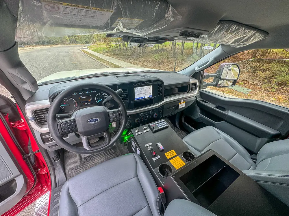 Wide front cabin interior view from open driver door.