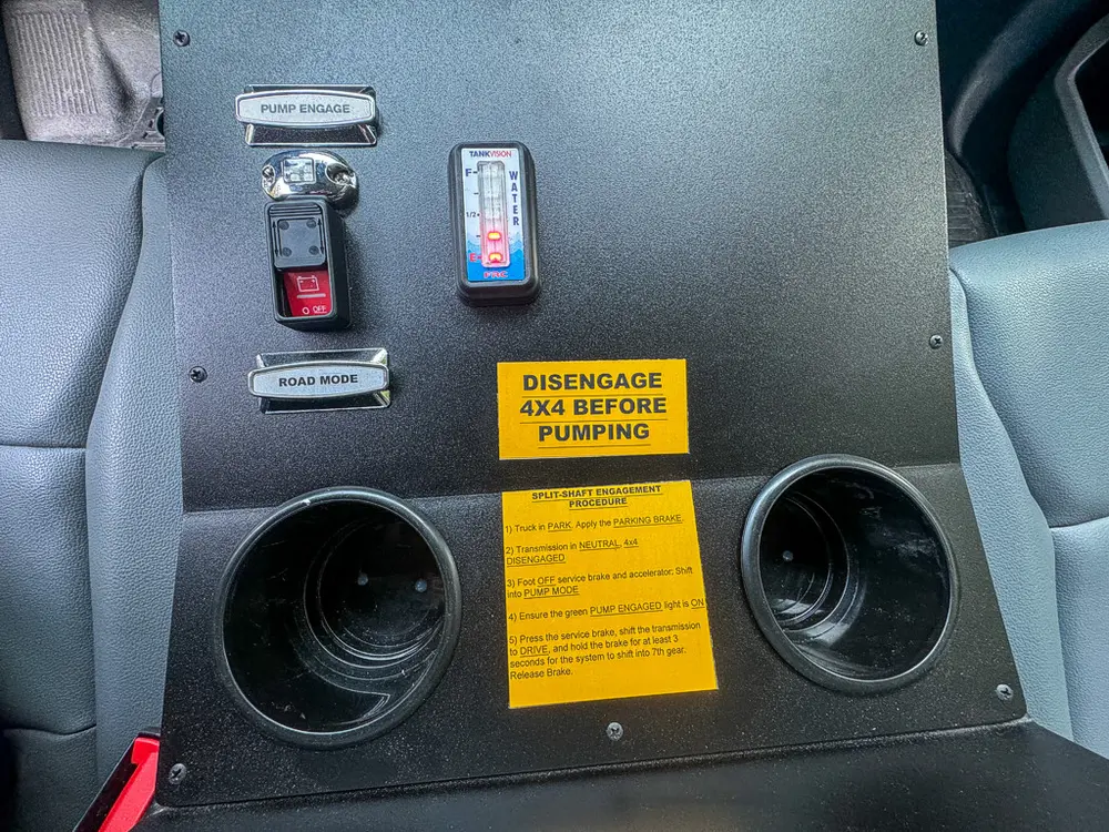 Console close-up with warning label and emergency control levers.