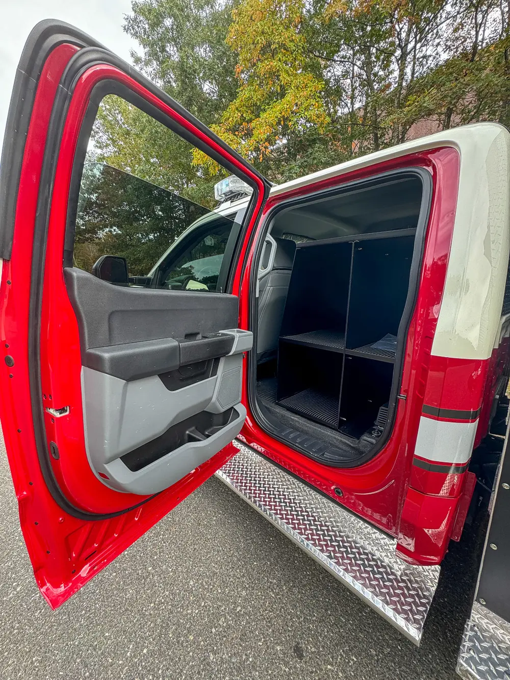 Open rear passenger door view with rear equipment cabinet.