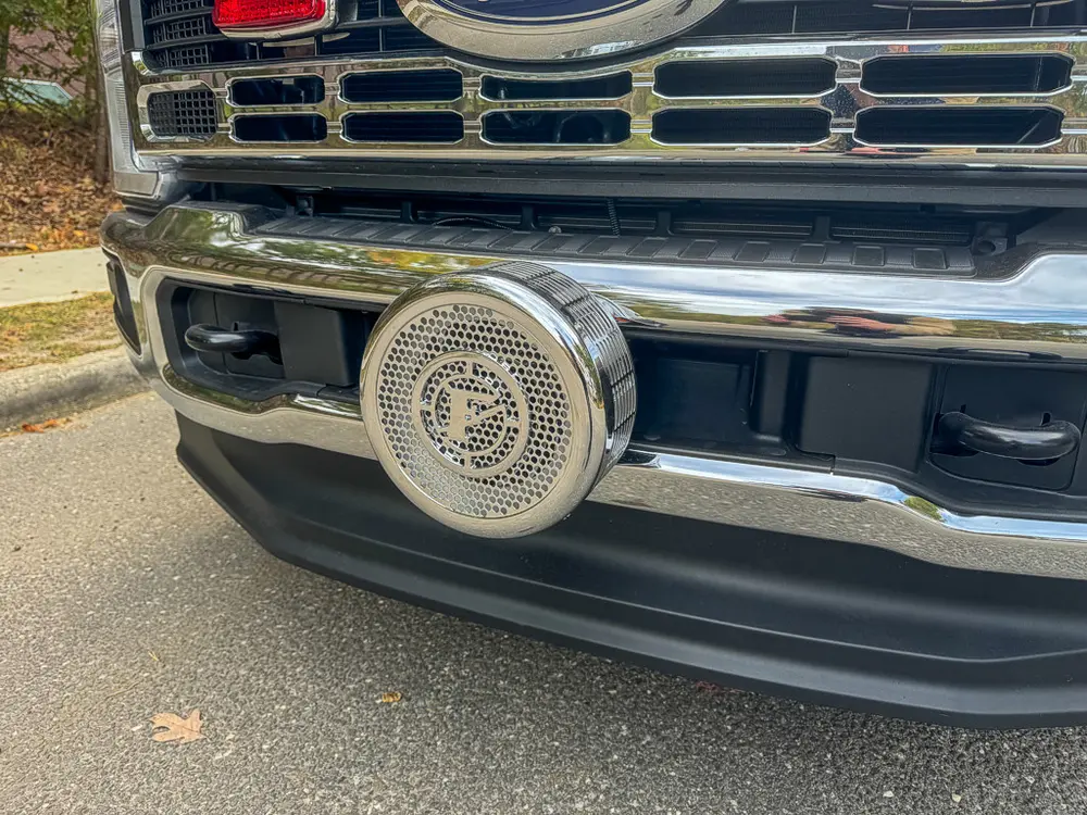 Front bumper close-up with grille and mounted siren speaker.
