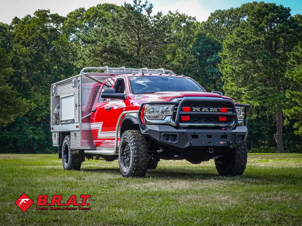 Exterior view of small fire truck showing cab, body compartments, and wheel/tire area.