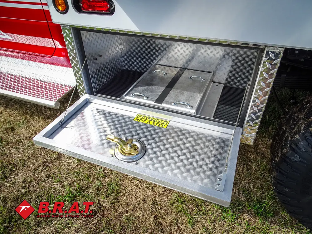 Exterior view of small fire truck showing cab, body compartments, and wheel/tire area.