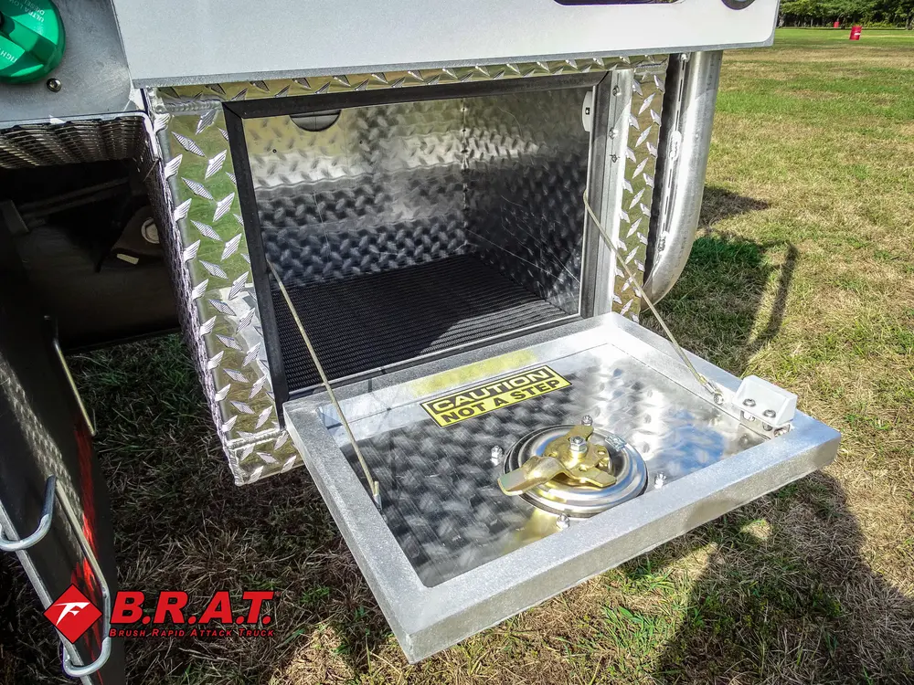 Exterior view of small fire truck showing cab, body compartments, and wheel/tire area.