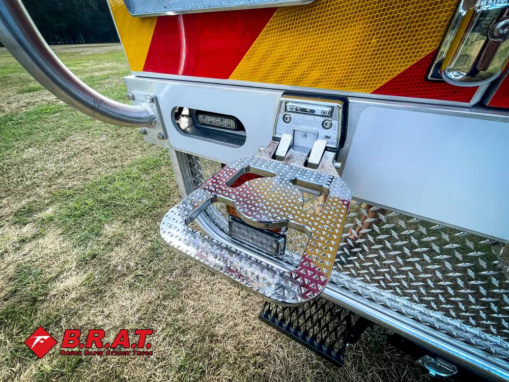 Exterior view of small fire truck showing cab, body compartments, and wheel/tire area.