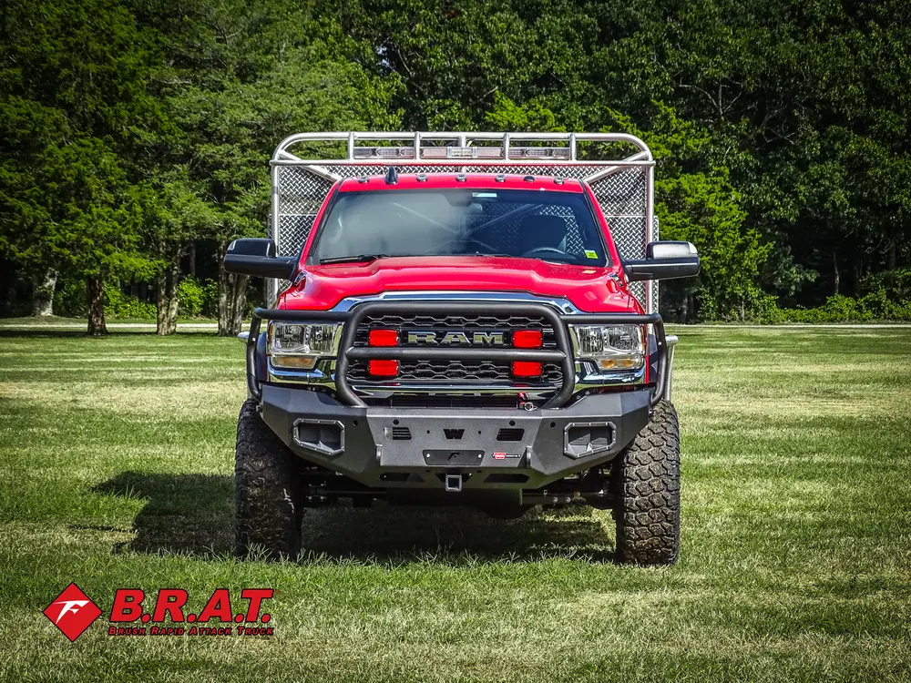 Exterior view of small fire truck showing cab, body compartments, and wheel/tire area.