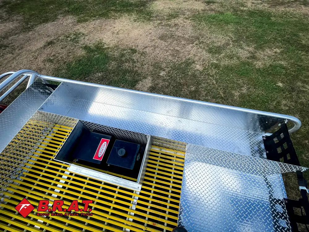 Exterior view of small fire truck showing cab, body compartments, and wheel/tire area.