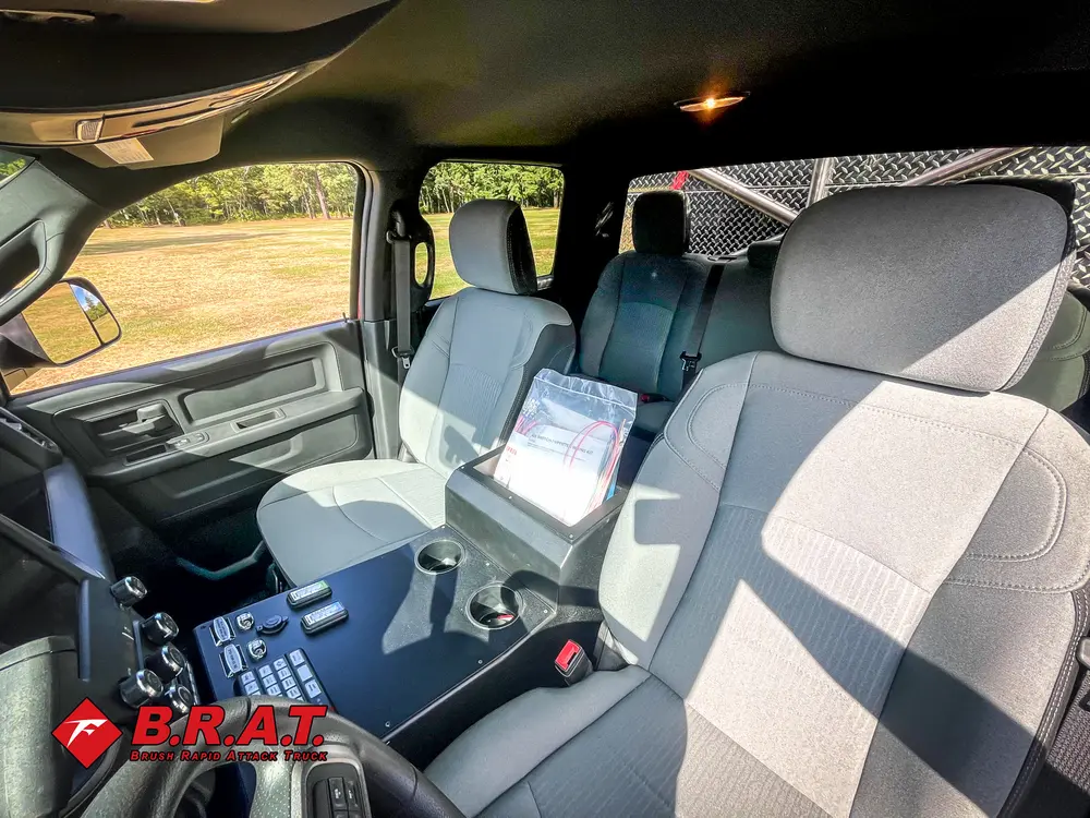 Exterior view of small fire truck showing cab, body compartments, and wheel/tire area.