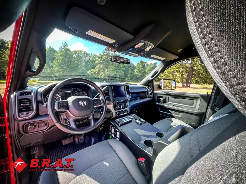 Exterior view of small fire truck showing cab, body compartments, and wheel/tire area.