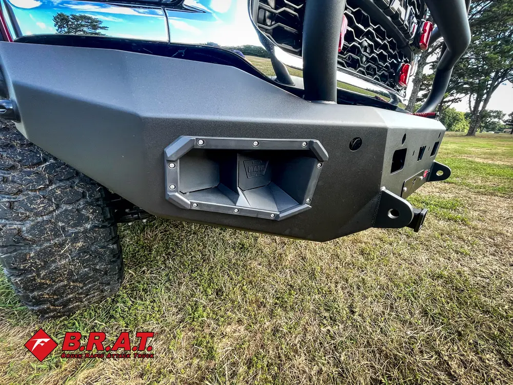 Exterior view of small fire truck showing cab, body compartments, and wheel/tire area.