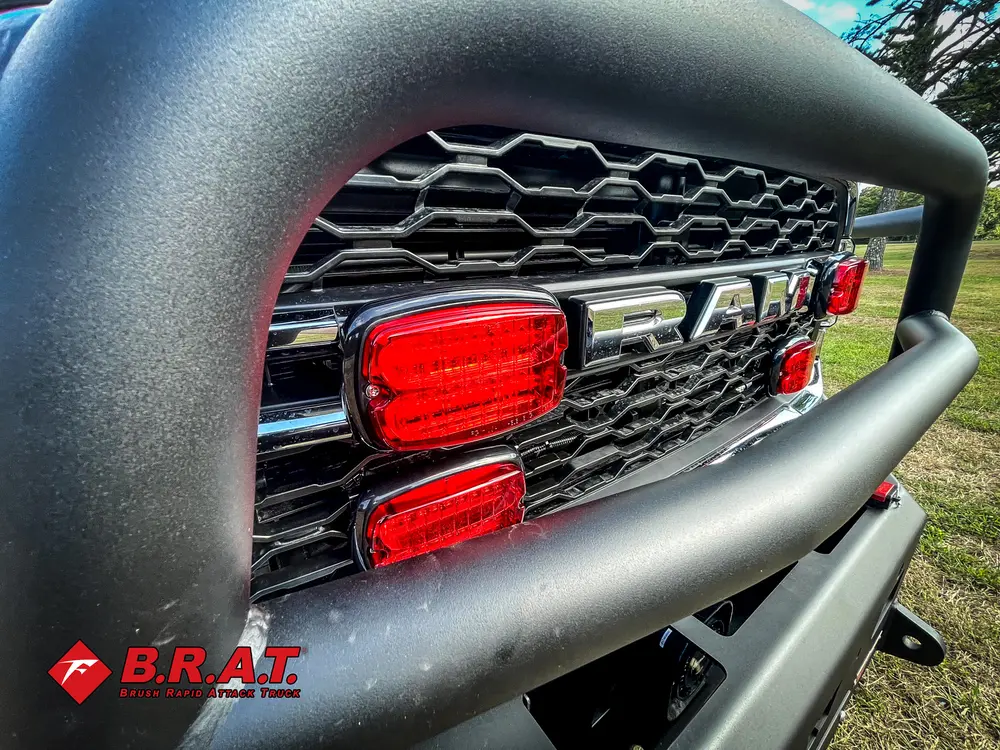 Exterior view of small fire truck showing cab, body compartments, and wheel/tire area.