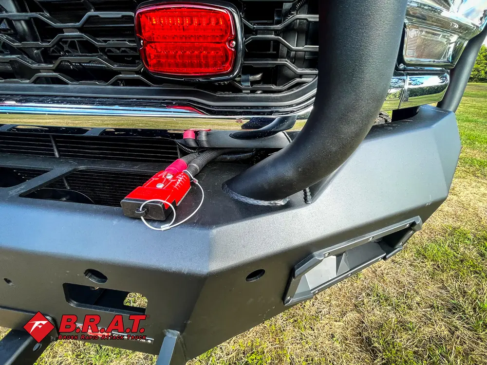 Exterior view of small fire truck showing cab, body compartments, and wheel/tire area.