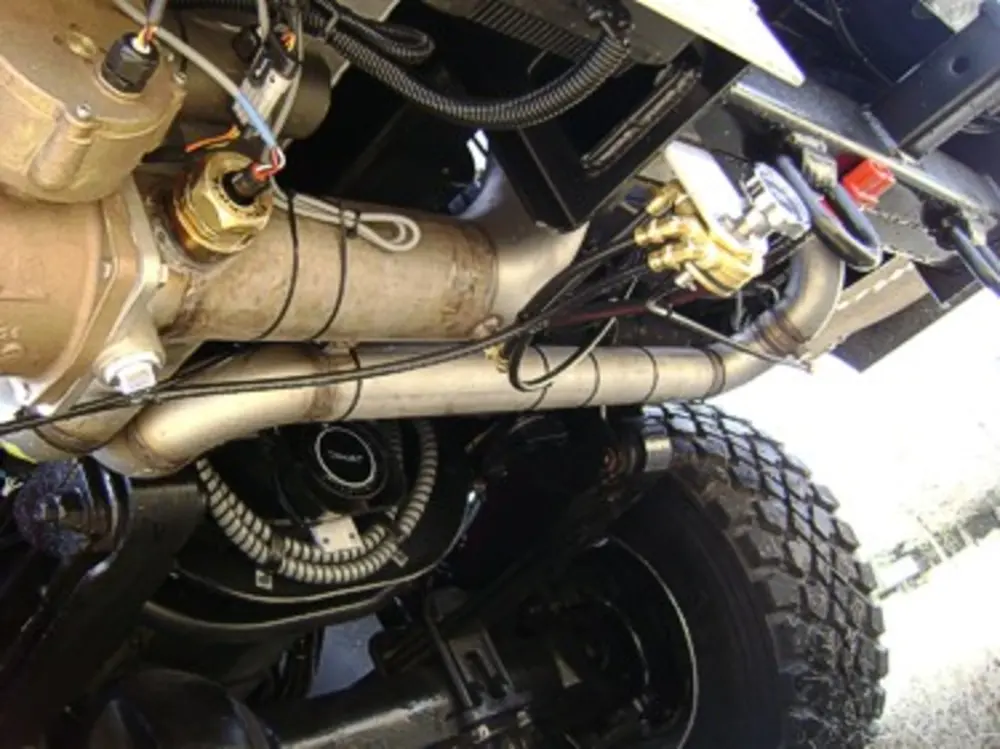 Exterior view of small fire truck showing cab, body compartments, and wheel/tire area.