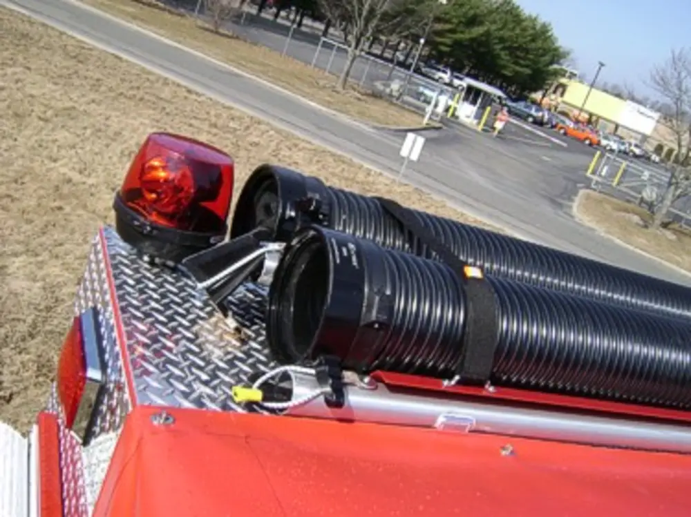 Exterior view of small fire truck showing cab, body compartments, and wheel/tire area.