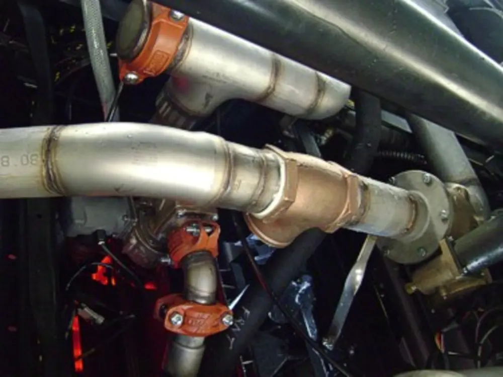 Exterior view of small fire truck showing cab, body compartments, and wheel/tire area.