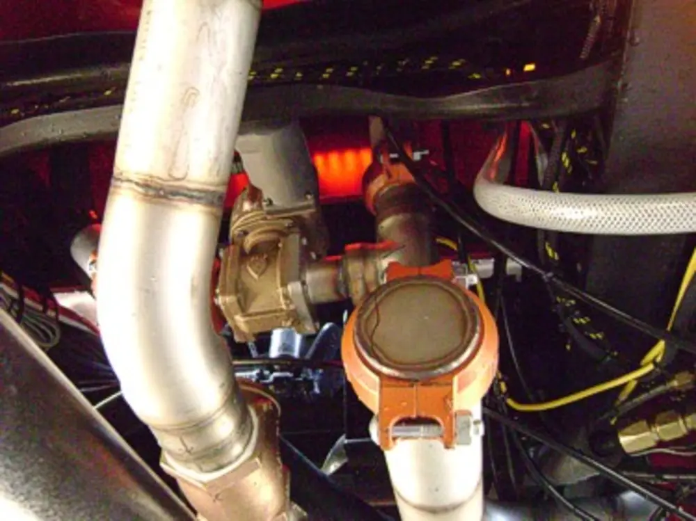 Exterior view of small fire truck showing cab, body compartments, and wheel/tire area.