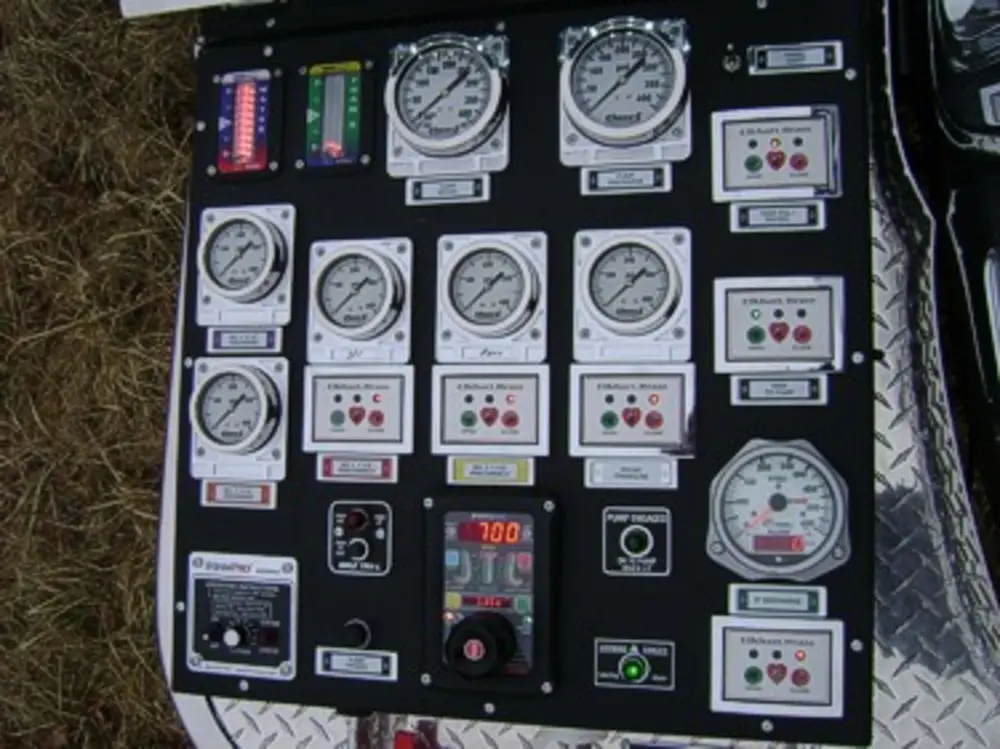 Exterior view of small fire truck showing cab, body compartments, and wheel/tire area.