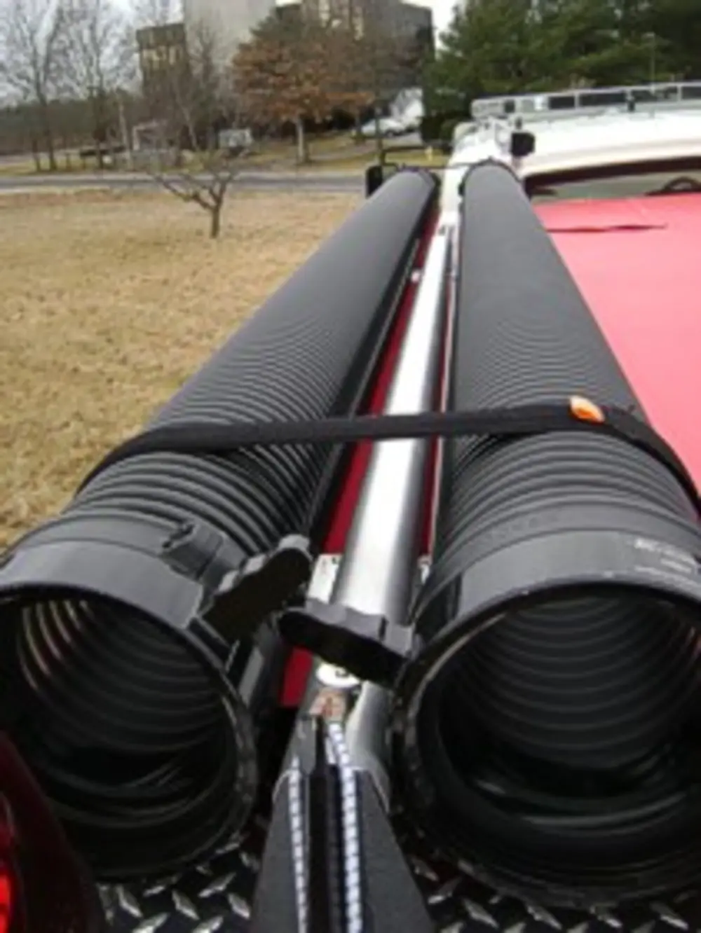 Exterior view of small fire truck showing cab, body compartments, and wheel/tire area.