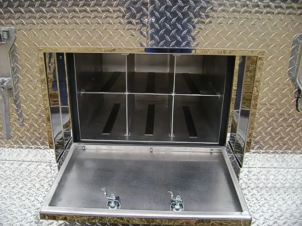 Exterior view of small fire truck showing cab, body compartments, and wheel/tire area.